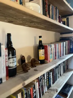 a shelf with two bottles of beer and books at Le Refuge in Chamonix-Mont-Blanc