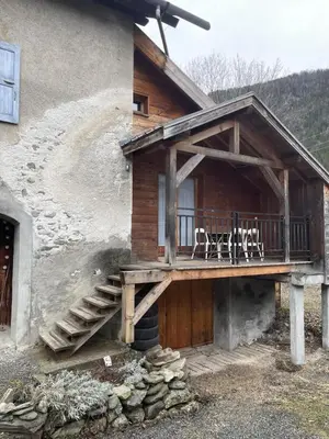 a house with a balcony with tables and chairs on it at Le Refuge in Chamonix-Mont-Blanc