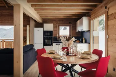 a kitchen and dining room with a table and red chairs at Chalet Alpage du Bettex - OVO Network in Mémontel