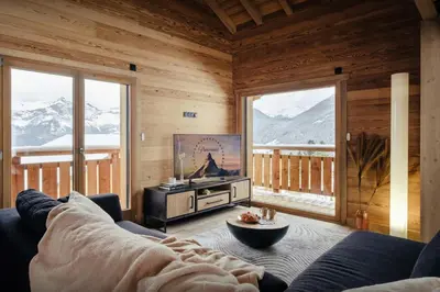 a living room with a couch and a tv and mountains at Chalet Alpage du Bettex - OVO Network in Mémontel