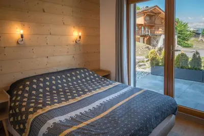 a bedroom with a bed and a large window at Le Saint Gervolain in Saint-Gervais-les-Bains