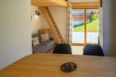 a room with a table and chairs and a couch at Le Saint Gervolain in Saint-Gervais-les-Bains