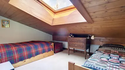 a attic bedroom with two beds and a skylight at 1 Sporting Acacia 2 - JAILLET - in Megève