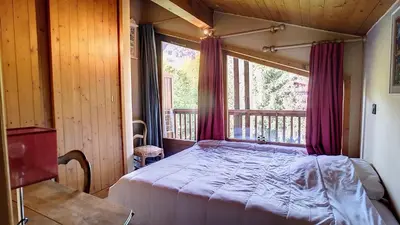 a bedroom with a bed and a large window at 1 Sporting Acacia 2 - JAILLET - in Megève