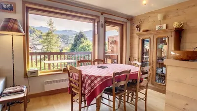 a dining room with a table and a large window at 1 Sporting Acacia 2 - JAILLET - in Megève