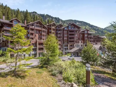 a large apartment building in the mountains with trees at Appartement 2 Pièces Pied des Pistes avec Wi-Fi et Parking - FR-1-687-120 in Arâches-la-Frasse