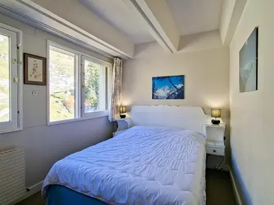 a bedroom with a white bed and two windows at Appartement spacieux, ski aux pieds, balcon, 3 pièces, 6-8 personnes - FR-1-425-238 in Arâches-la-Frasse