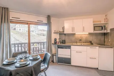 a kitchen with a table and chairs and a kitchen with a balcony at Appartement Le Nid des Sommets - Welkeys in Saint-Gervais-les-Bains