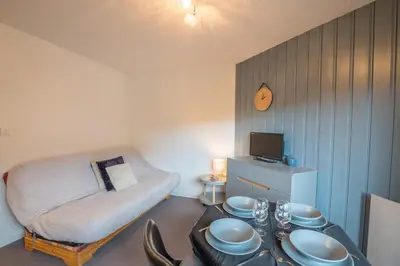 a room with a bed and a table with dishes on it at Appartement Le Nid des Sommets - Welkeys in Saint-Gervais-les-Bains