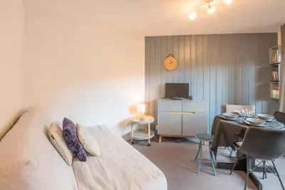 a bedroom with a bed and a dining room with a table at Appartement Le Nid des Sommets - Welkeys in Saint-Gervais-les-Bains