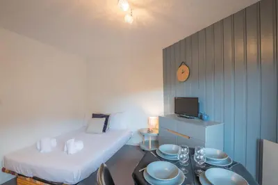 a room with a bed and a table with dishes on it at Appartement Le Nid des Sommets - Welkeys in Saint-Gervais-les-Bains