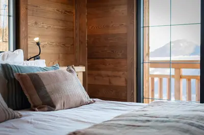 a bed in a room with a large window at Chalet de l'Emey - 12 pers in Mémontel