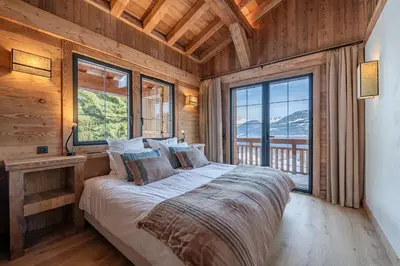 a bed in a room with a large window at Chalet de l'Emey - 12 pers in Mémontel