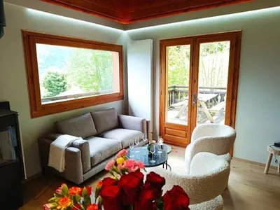 a living room with a couch and a table and flowers at Le Cairn in Saint-Gervais-les-Bains