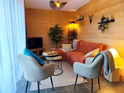 a living room with a couch and chairs and a tv at L'Alpin C in Le Fayet