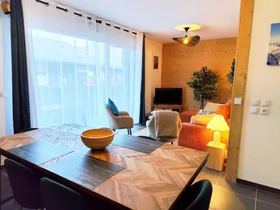 a living room with a dining table and a living room at L'Alpin C in Le Fayet