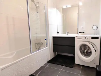 a bathroom with a washing machine and a shower at L'Alpin C in Le Fayet