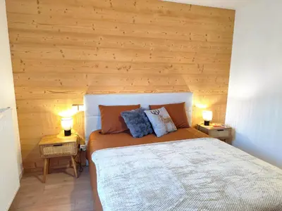 a bedroom with a large bed with wooden walls at L'Alpin C in Le Fayet