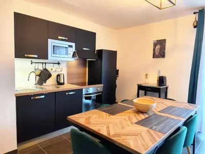 a kitchen with a wooden table and a dining room at L'Alpin C in Le Fayet