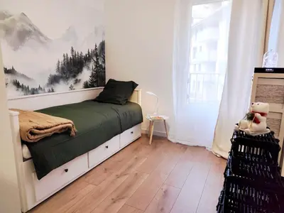 a bedroom with a bed with a painting on the wall at L'Alpin C in Le Fayet