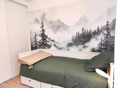 a bedroom with a bed with a mountain mural on the wall at L'Alpin C in Le Fayet