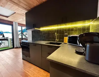 a kitchen with a sink and a counter top at Appart Hyper Centre Chamonix balcon parking privé in Chamonix-Mont-Blanc