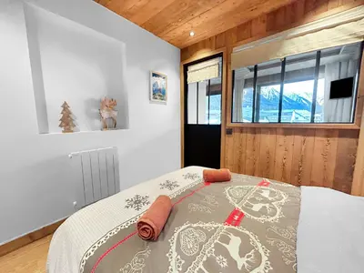a bedroom with a bed and a window at Appart Hyper Centre Chamonix balcon parking privé in Chamonix-Mont-Blanc