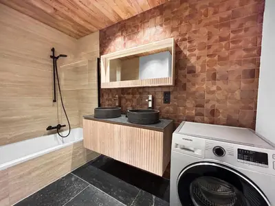 a bathroom with a washing machine and a mirror at Appart Hyper Centre Chamonix balcon parking privé in Chamonix-Mont-Blanc