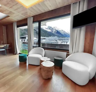a living room with two chairs and a large window at Appart Hyper Centre Chamonix balcon parking privé in Chamonix-Mont-Blanc
