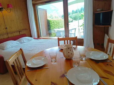 a wooden table with plates and glasses on top of it at Les hautes Cimes in Saint-Gervais-les-Bains