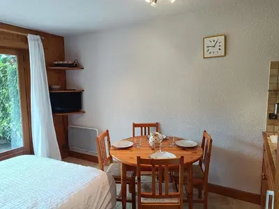 a dining room table with chairs and a clock on the wall at Les hautes Cimes in Saint-Gervais-les-Bains