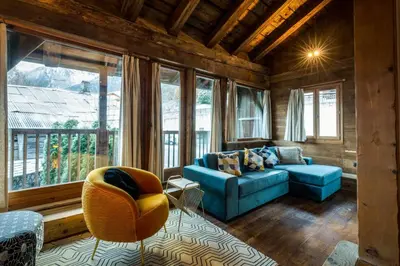 a living room with a blue couch and windows at Rosaline Ferme 220m2 Charme Cheminee Jacuzzi Sauna in Les Houches