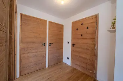 a hallway with two wooden doors in a house at Canopée Duplex 4 CH Proche Remontees Central Vues in Saint-Gervais-les-Bains