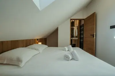 a white bed with two towels on top of it at Canopée Duplex 4 CH Proche Remontees Central Vues in Saint-Gervais-les-Bains