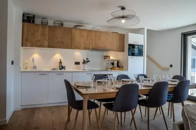 a kitchen and dining room with a table and chairs at Canopée Duplex 4 CH Proche Remontees Central Vues in Saint-Gervais-les-Bains