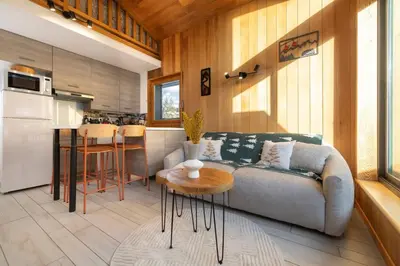a living room with a couch and a table and a kitchen at Petit Montana Apart 2CH Vues Garage 5mn Grands Montets in Chamonix-Mont-Blanc