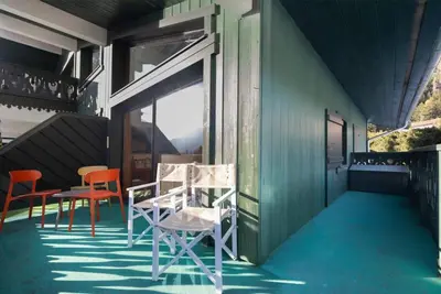 a porch with chairs and a table and a window at Petit Montana Apart 2CH Vues Garage 5mn Grands Montets in Chamonix-Mont-Blanc