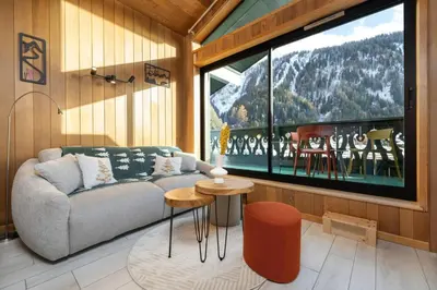 a living room with a couch and a large window at Petit Montana Apart 2CH Vues Garage 5mn Grands Montets in Chamonix-Mont-Blanc