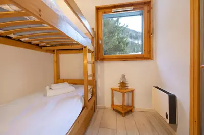 a room with two bunk beds and a window at Petit Montana Apart 2CH Vues Garage 5mn Grands Montets in Chamonix-Mont-Blanc