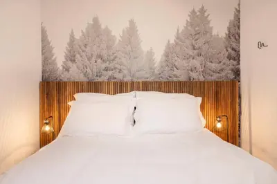 a bedroom with a bed with white pillows and trees at Petit Montana Apart 2CH Vues Garage 5mn Grands Montets in Chamonix-Mont-Blanc