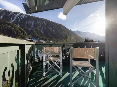 a balcony with two chairs and a view of a mountain at Petit Montana Apart 2CH Vues Garage 5mn Grands Montets in Chamonix-Mont-Blanc