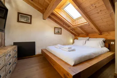 a bedroom with a bed in a wooden house at Momi Cocon 4pax Jardin Jacuzzi Vue in Chamonix-Mont-Blanc