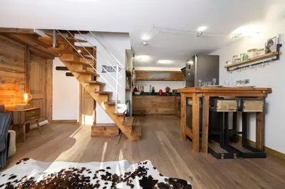 a kitchen and living room with a staircase in a house at Momi Cocon 4pax Jardin Jacuzzi Vue in Chamonix-Mont-Blanc