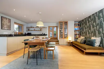a kitchen and living room with a table and a couch at Guérin Cosy 4pax Familial Vue Central in Chamonix-Mont-Blanc