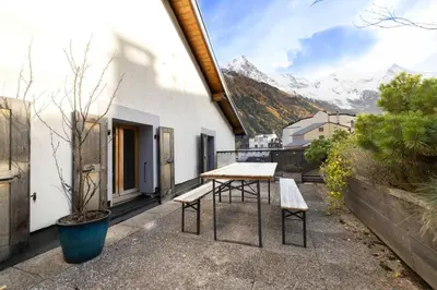 a table and benches on a balcony with mountains at Guérin Cosy 4pax Familial Vue Central in Chamonix-Mont-Blanc