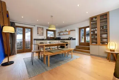 a kitchen with a table and chairs in a room at Guérin Cosy 4pax Familial Vue Central in Chamonix-Mont-Blanc