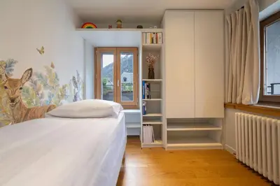 a bedroom with a bed and a book shelf at Guérin Cosy 4pax Familial Vue Central in Chamonix-Mont-Blanc