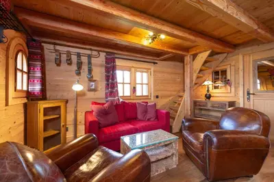 a living room with a red couch and leather chairs at Lays Mazot Calme Vues Parking in Saint-Gervais-les-Bains