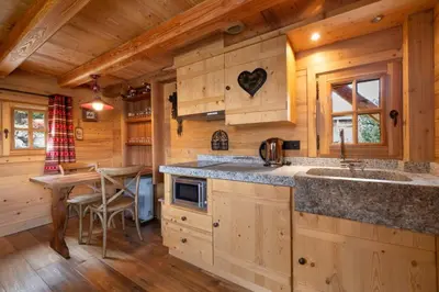 a kitchen with wooden cabinets and a table in a cabin at Lays Mazot Calme Vues Parking in Saint-Gervais-les-Bains