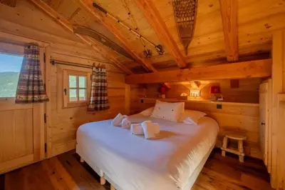 a bedroom with a large bed in a log cabin at Lays Mazot Calme Vues Parking in Saint-Gervais-les-Bains